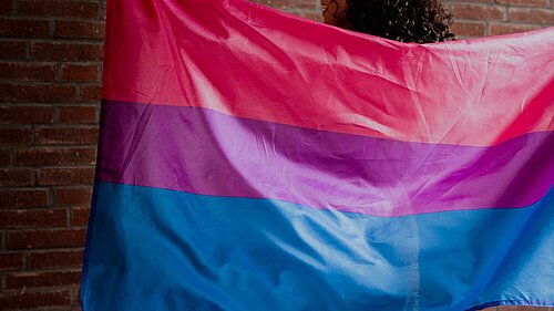 Woman holding a bisexual flag